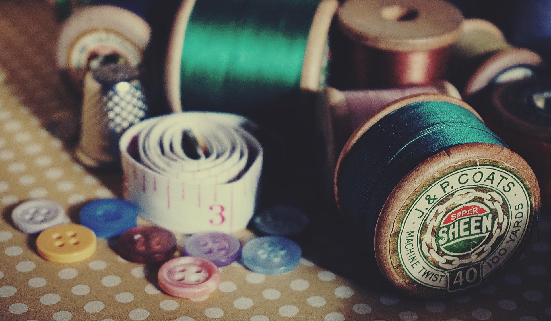 Green thread, measuring tape and buttons