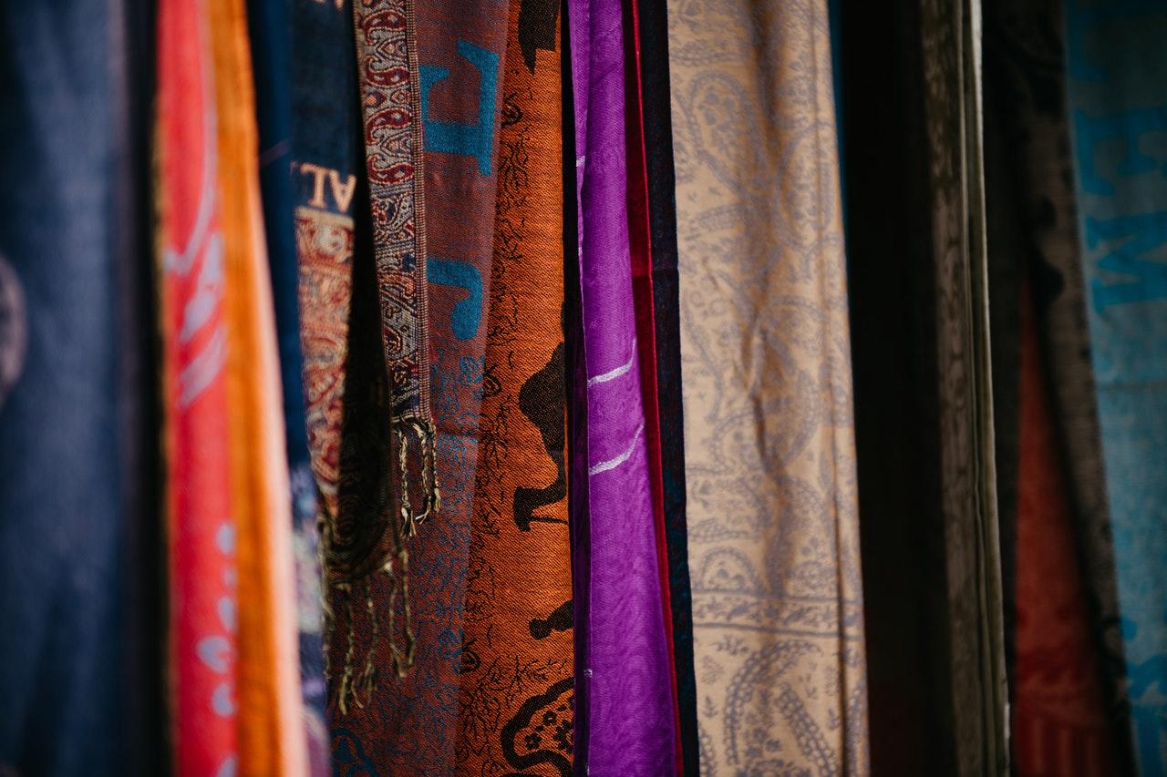 Different colored fabric with cool prints hanging vertically.