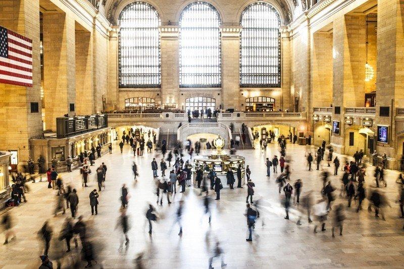 Commuters travel through a busy railway station