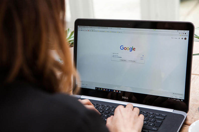 A woman composes an online google search.