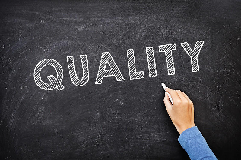 A man writes the word 'Quality'.