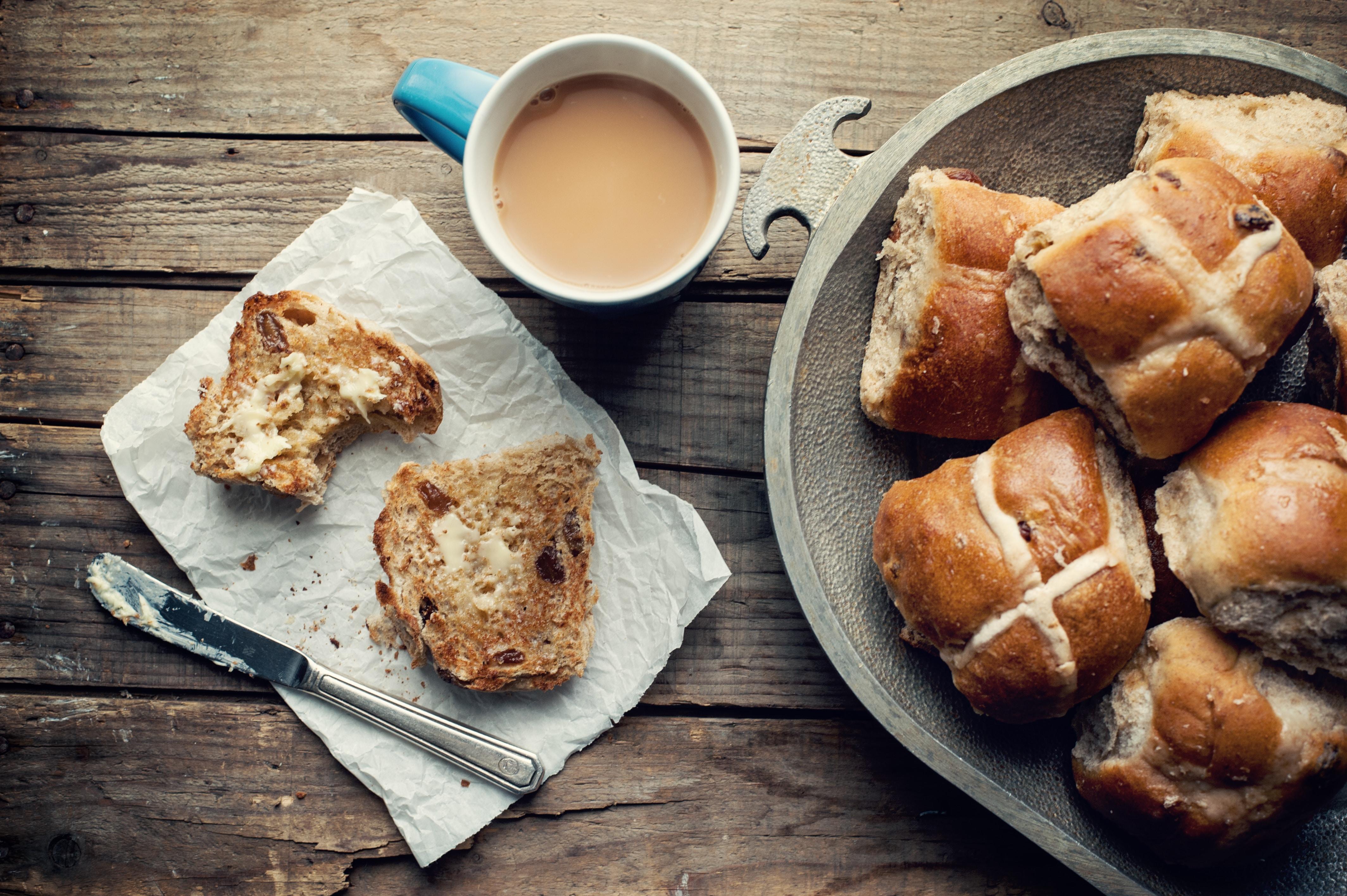Pastries sitting on a wooden table next to a cup of coffee.