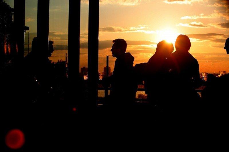 People talk amongst an evening sunset.