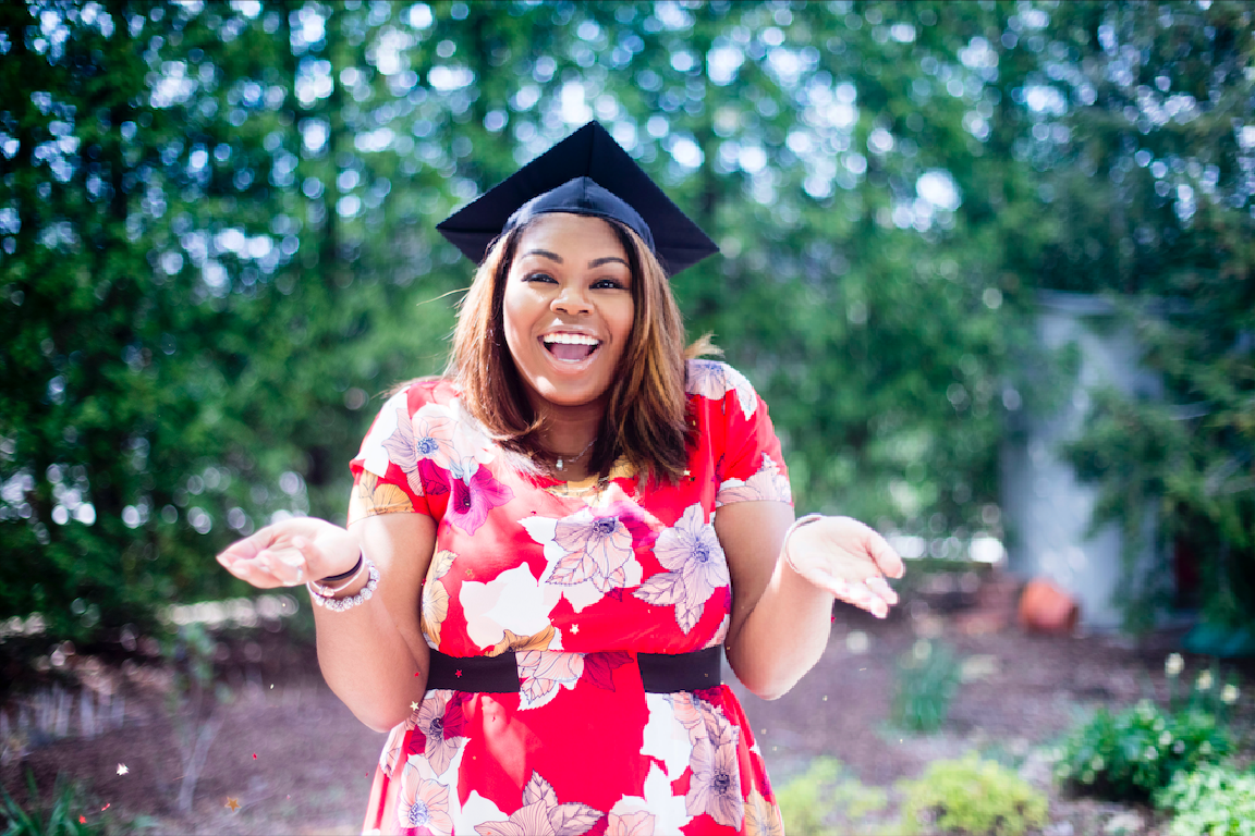 Smiling girl wearing a mortarboard in a red dress.