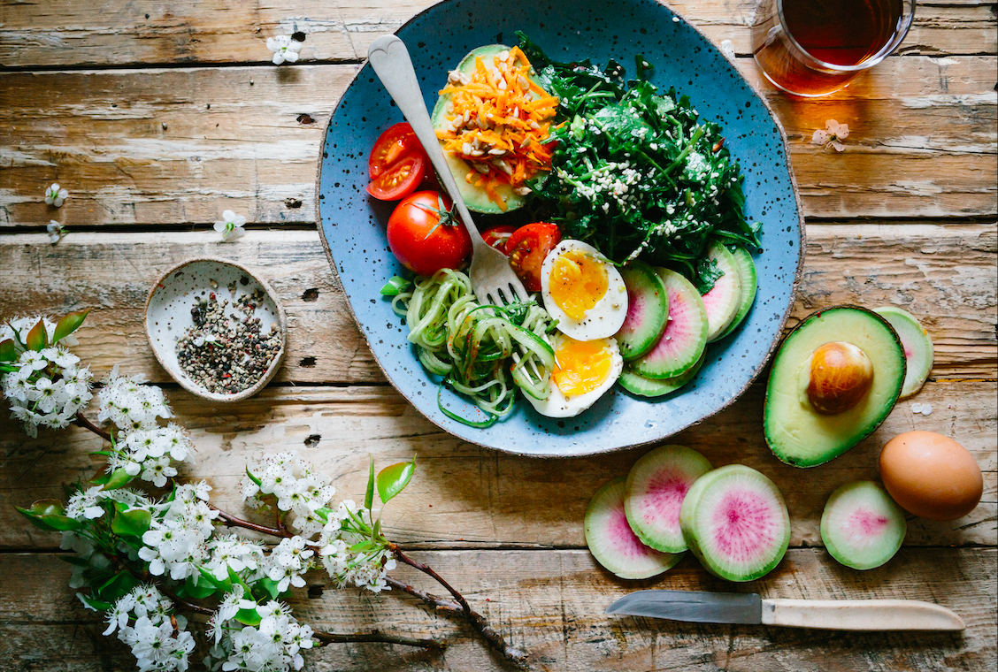 A bowl of salad sitting in a blue bowl.