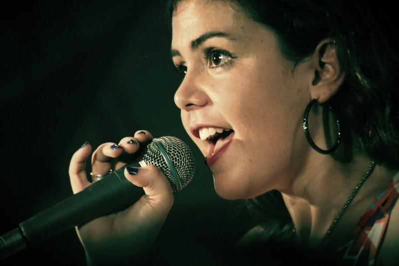A woman sings into a microphone.