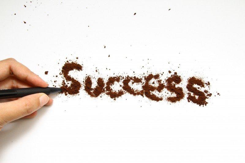 A man writes the word success.