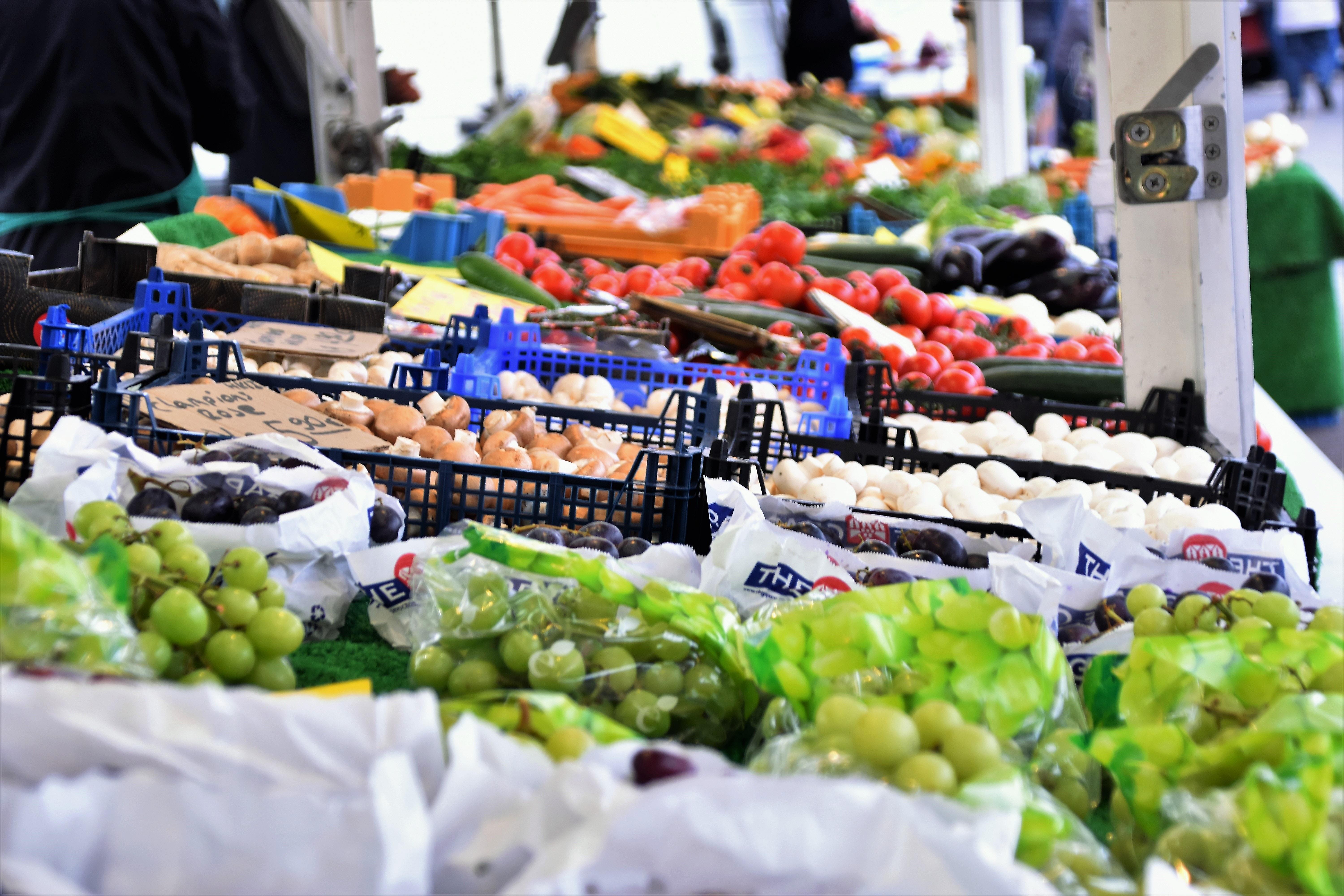 Multi-colored vegetables and fruits on display at a grocery store.