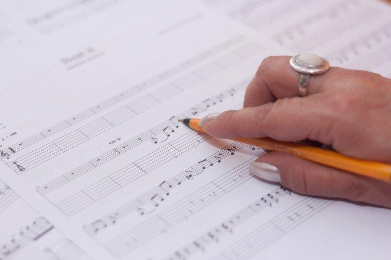 A woman writes sheet music