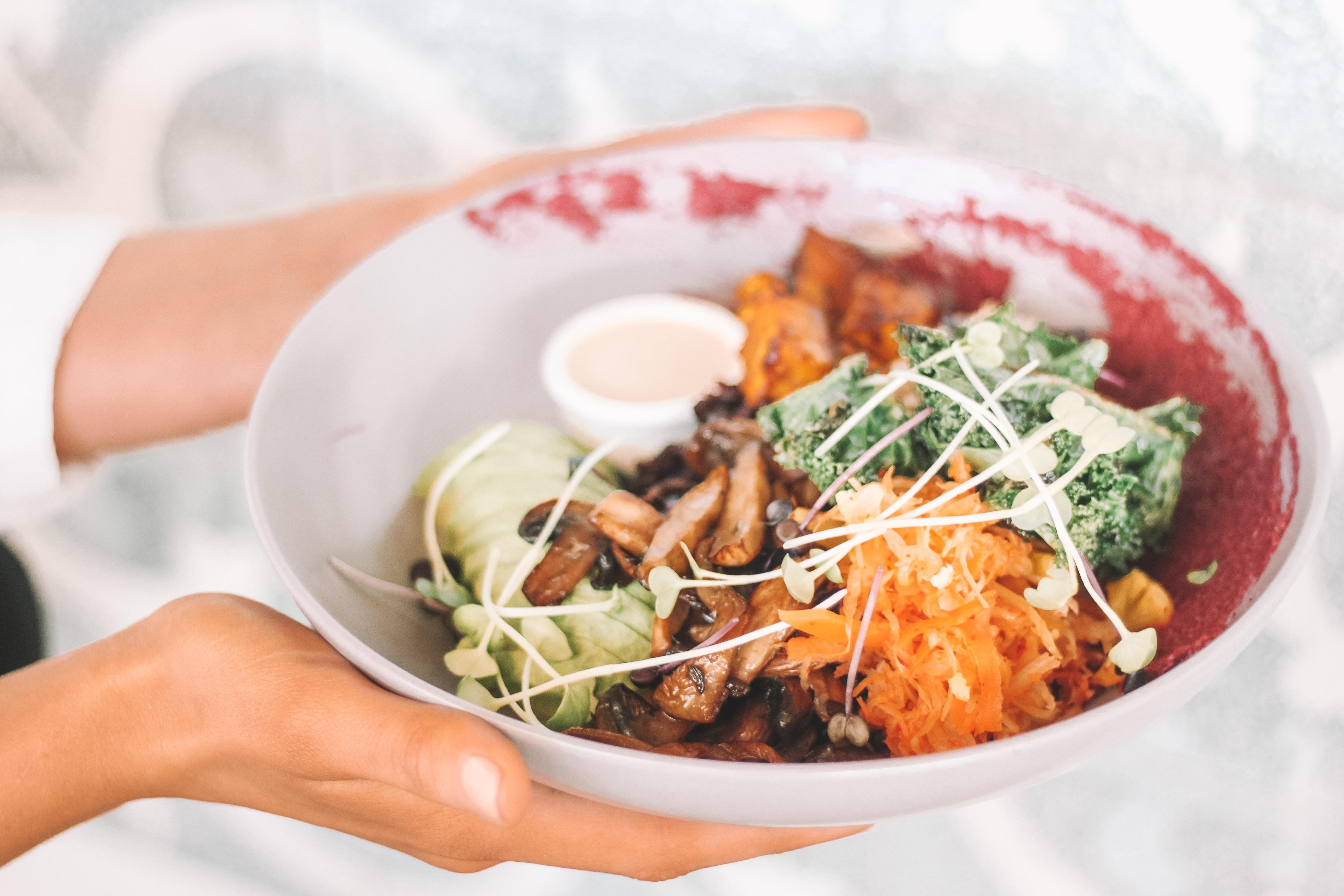 A hand holding a bowl of food.