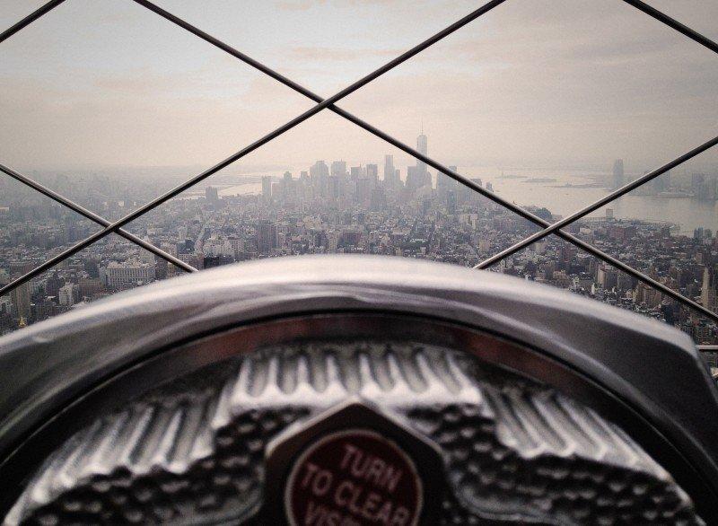 City skyline behind chainlink fence.