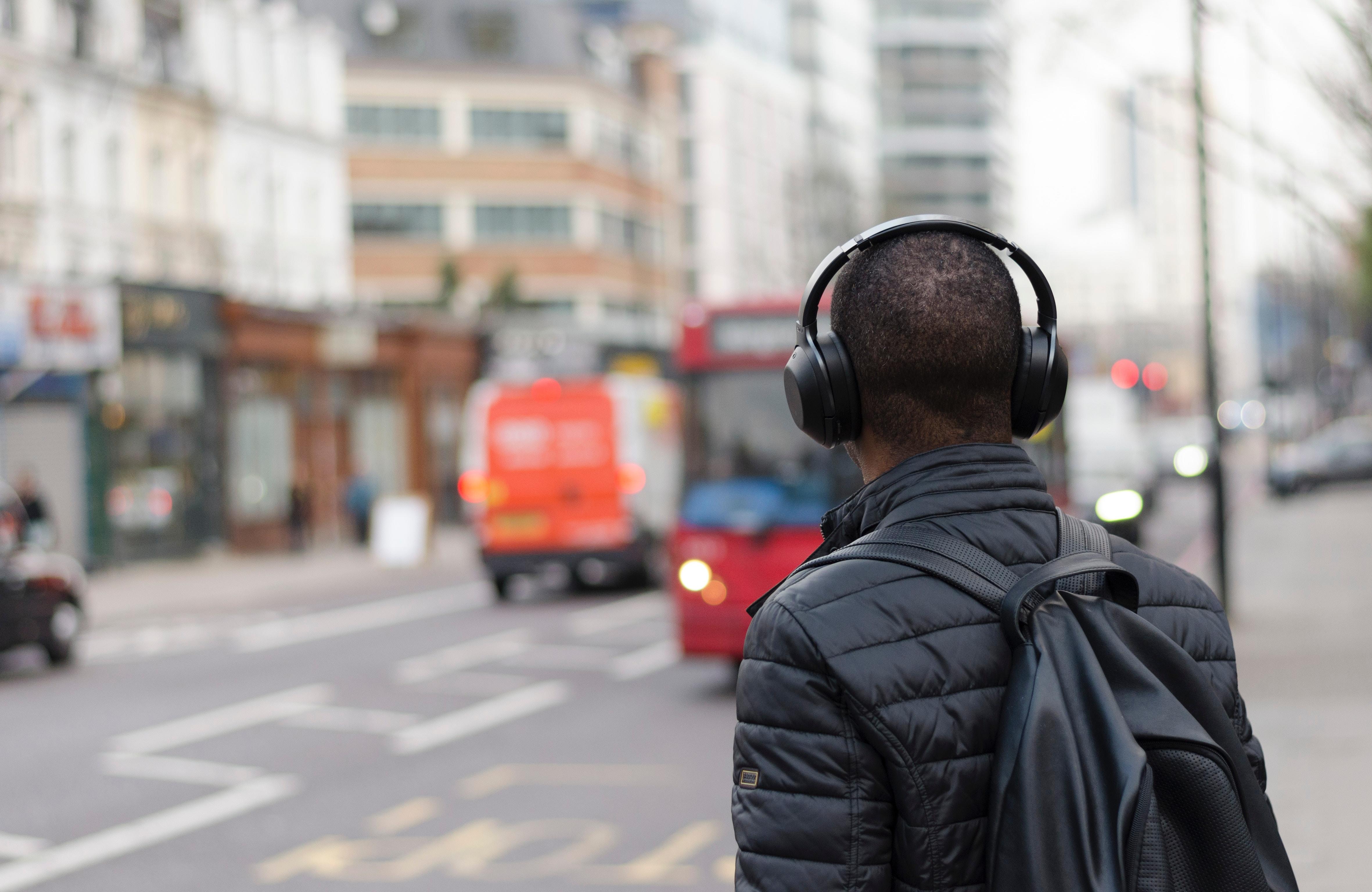 man crossing the road with headphones on