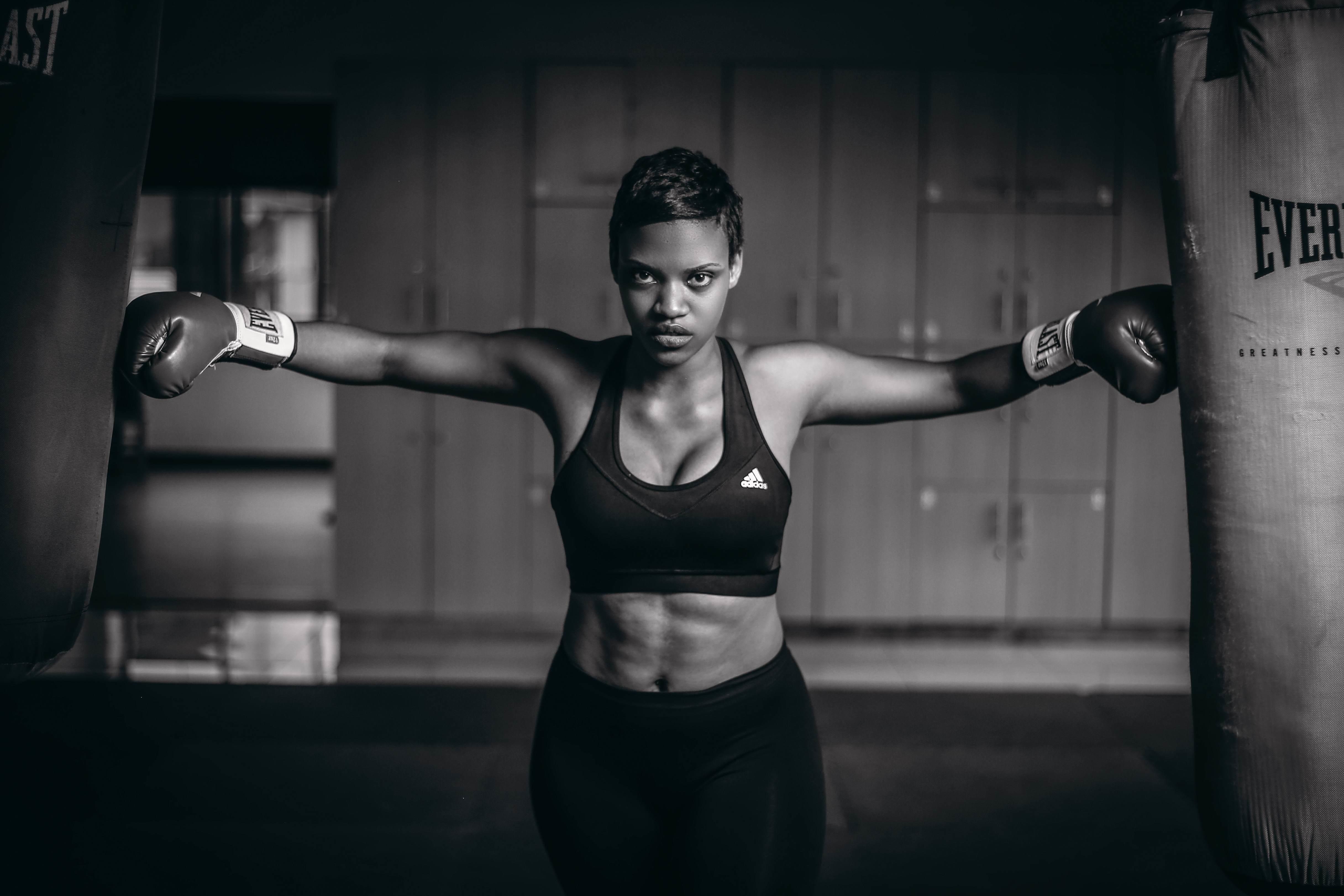 woman with boxing gloves posing with punching bags
