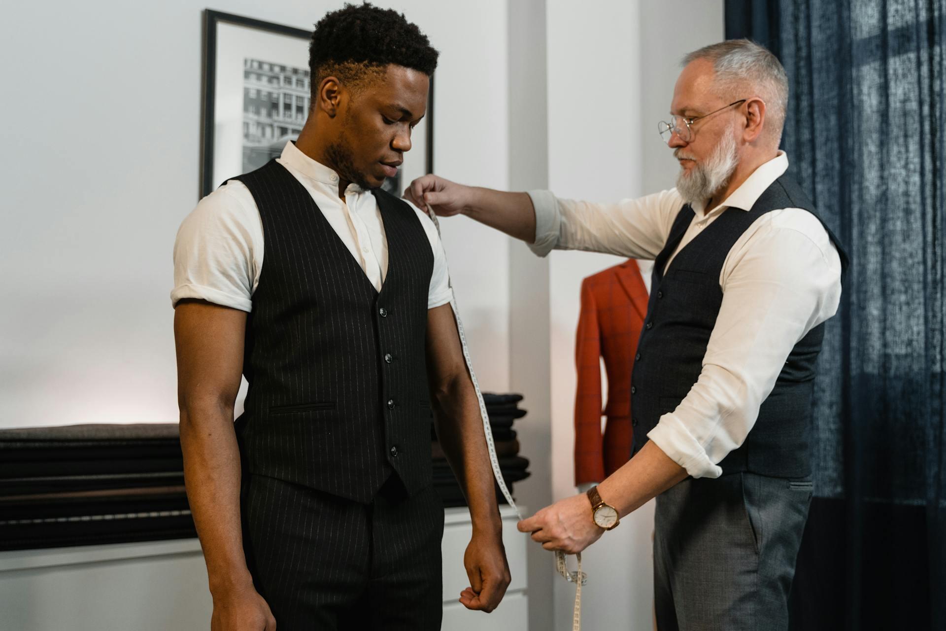 tailor measuring a client with measuring tape