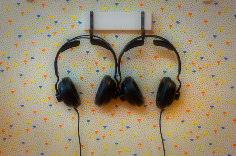 Two pairs of headphones hang from the wall.