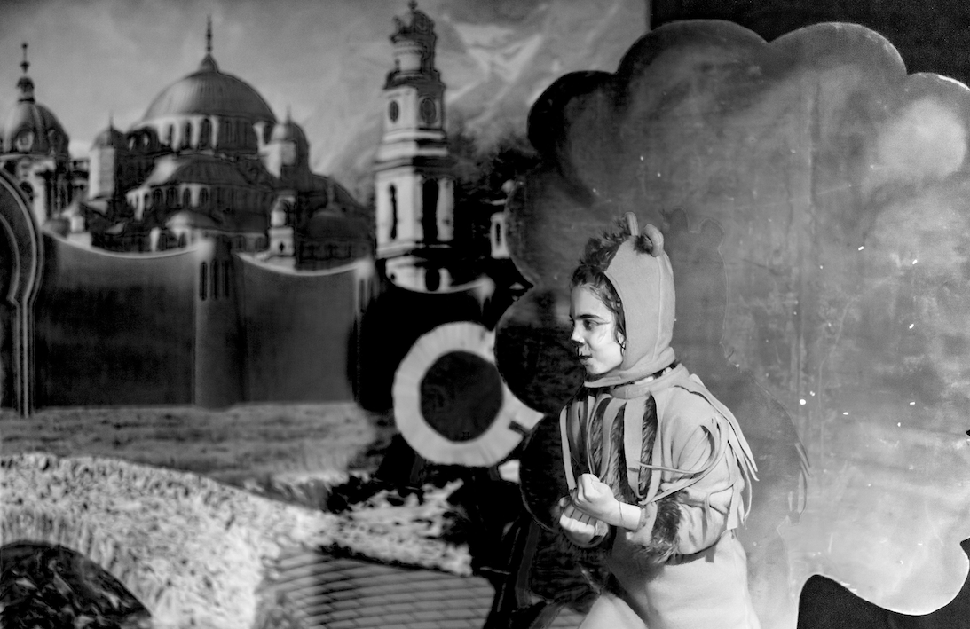 Black and while photo of a girl in costume performing on stage.