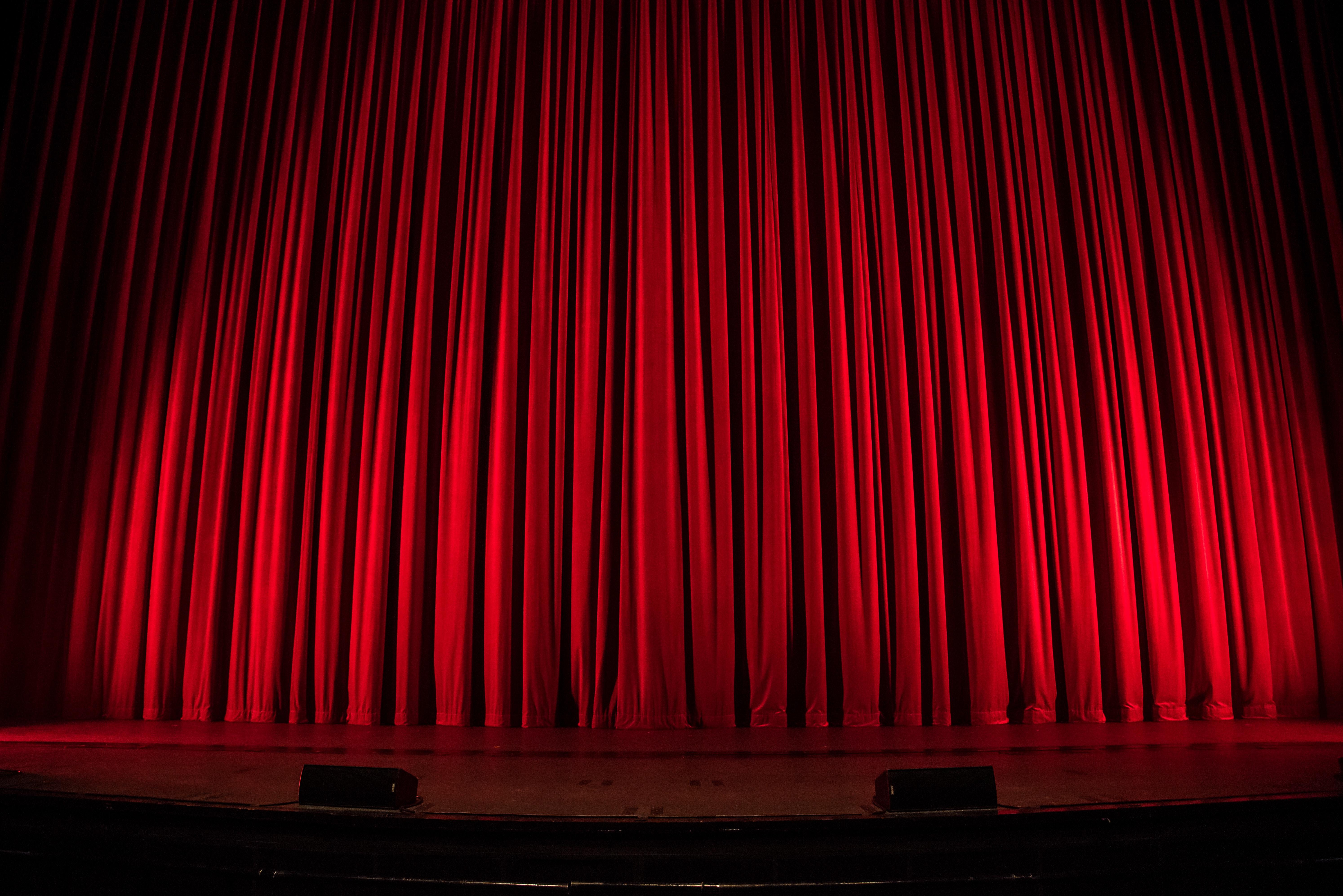 Red theatre curtains hanging down from the ceiling.