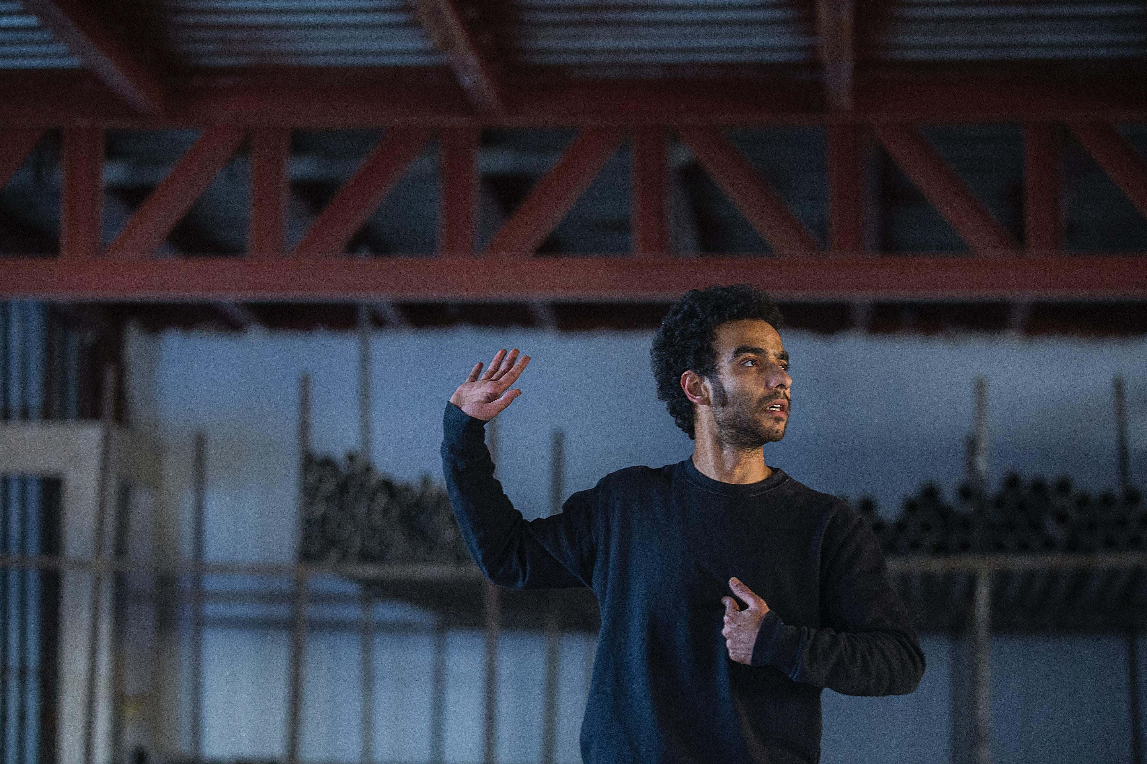 Man holding up one arm to act in a room.