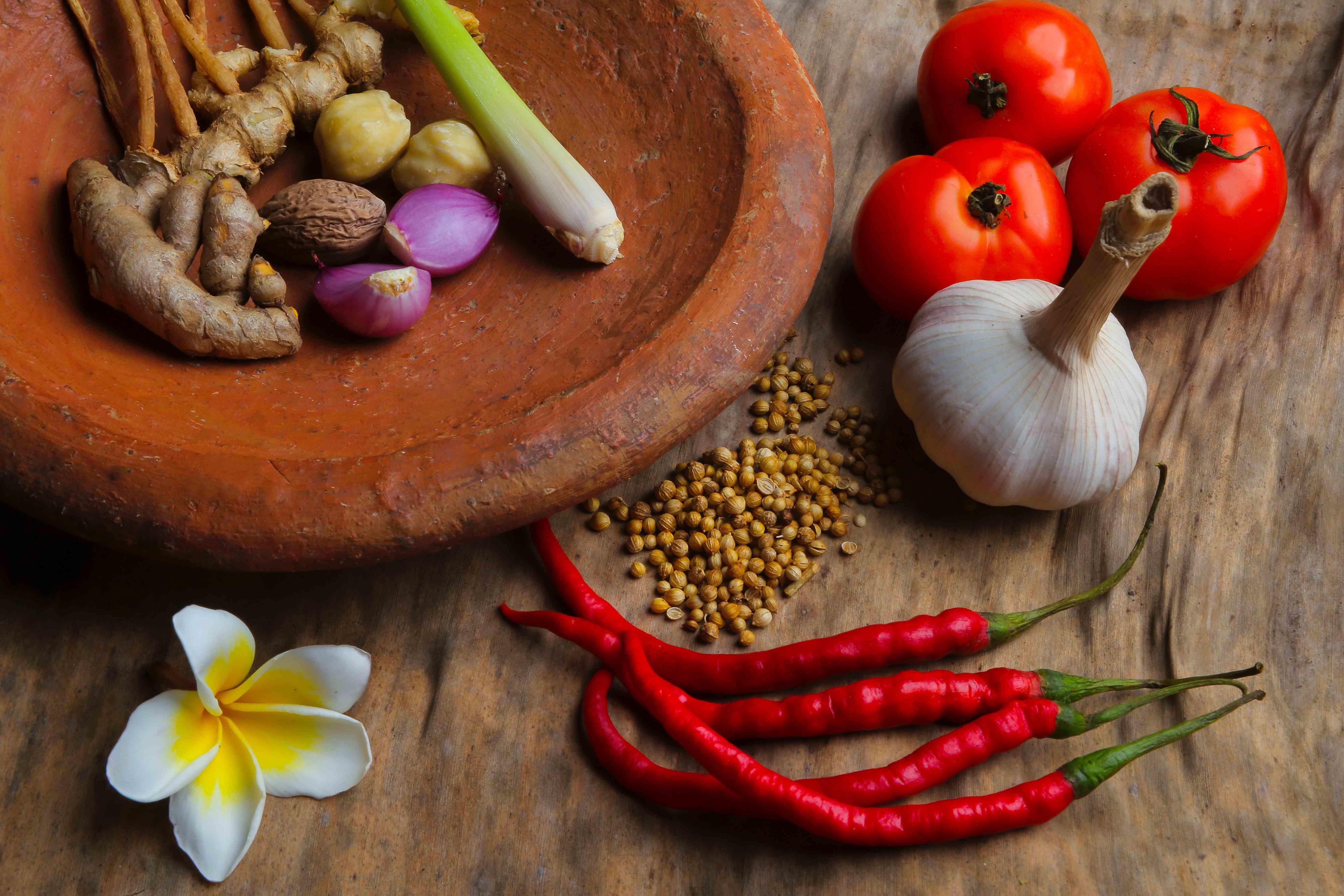 clay bowl filled with garlic, onions, peppers and spices.