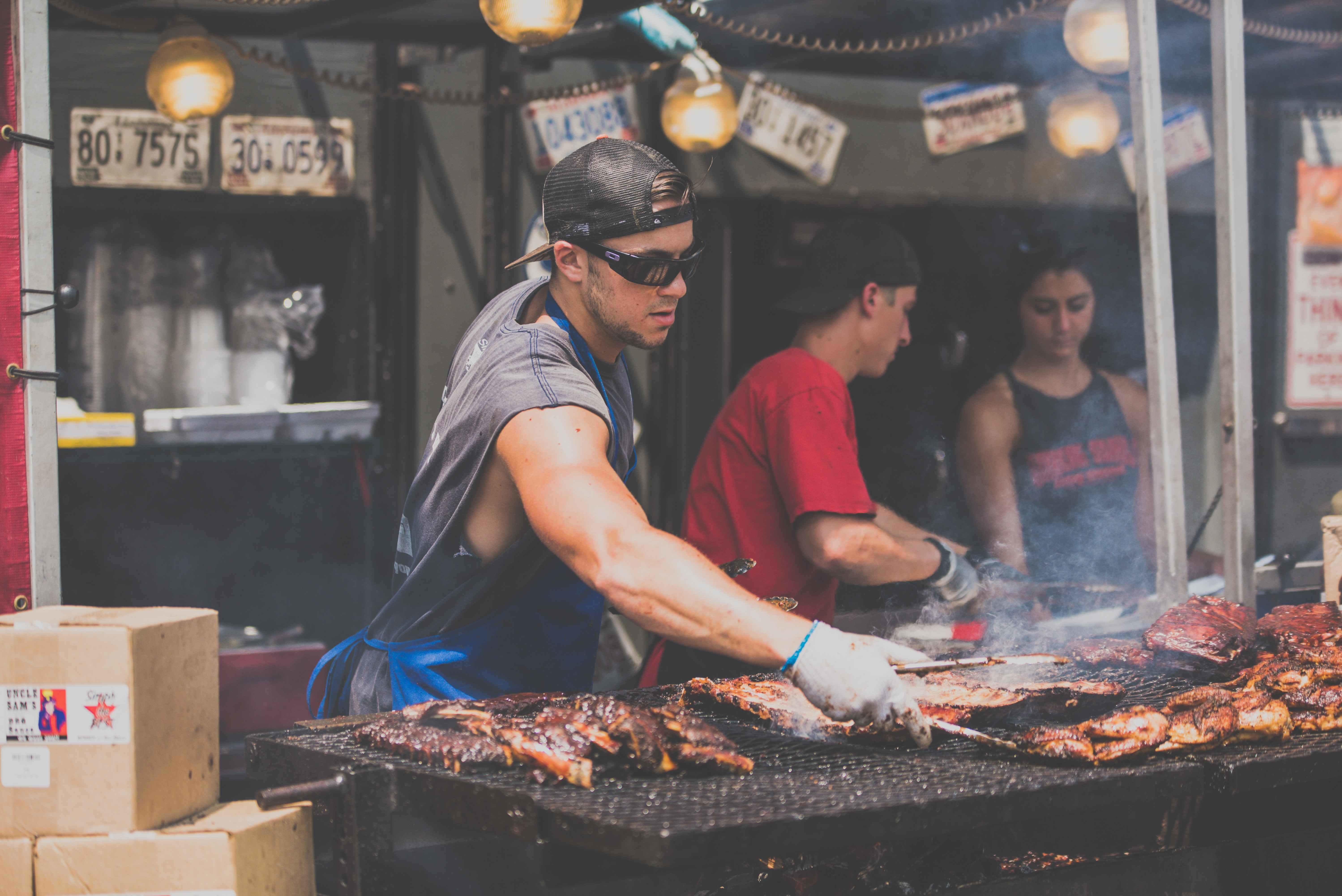guy cooking some ribs and meat on a bbq