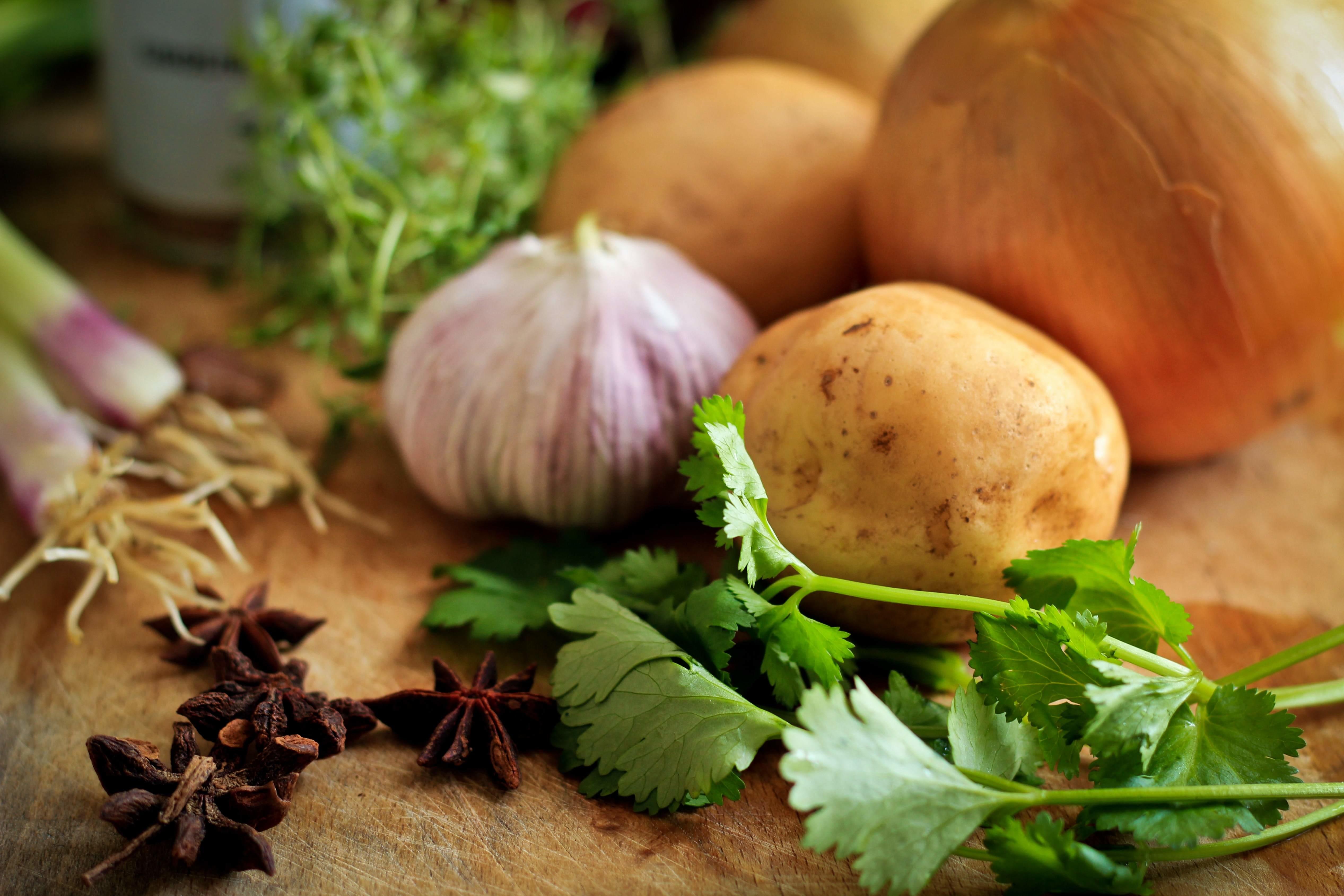 potatoes, herbs and onions in a cutting board