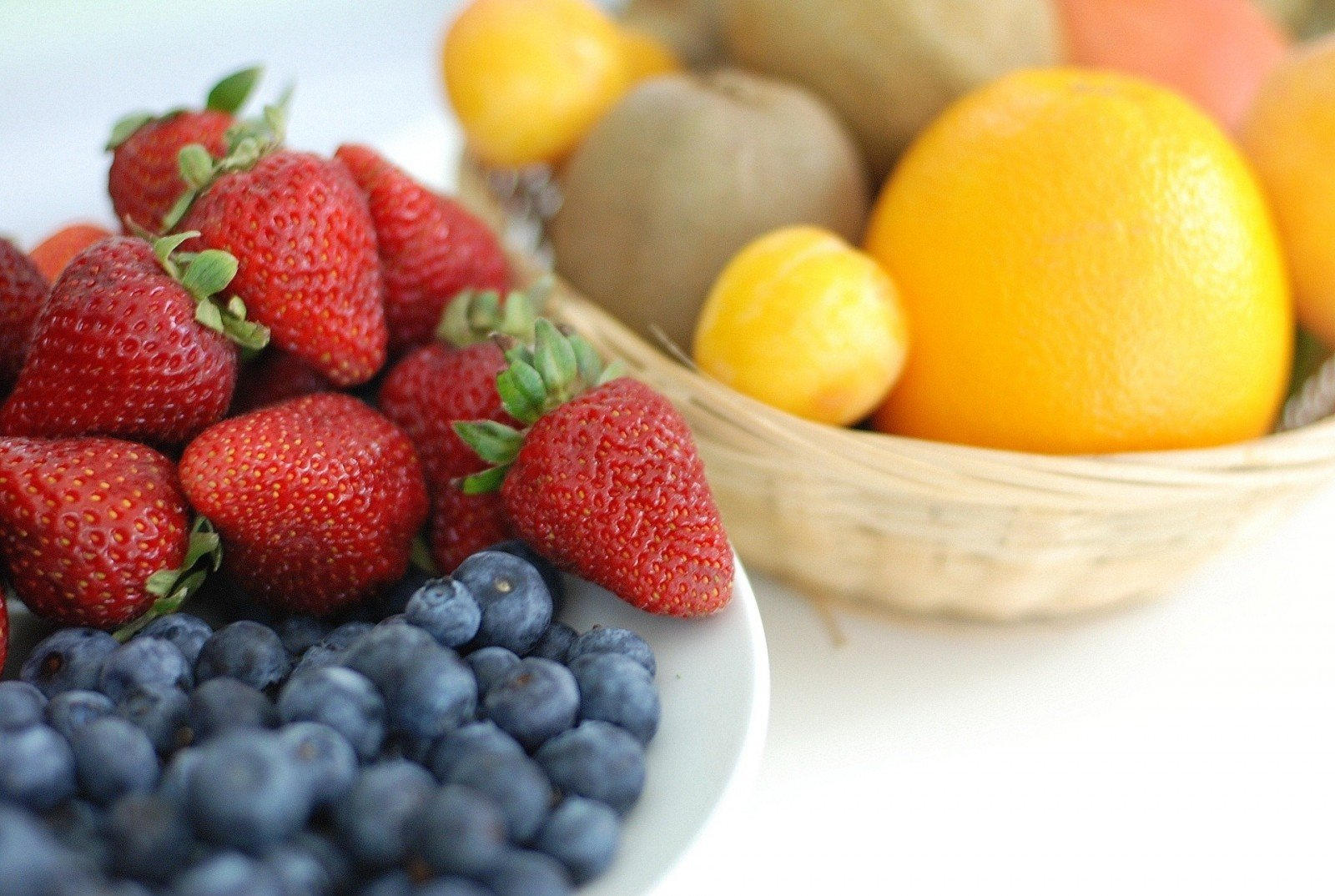 strawberries, blueberries and citrus fruits on a white bowl