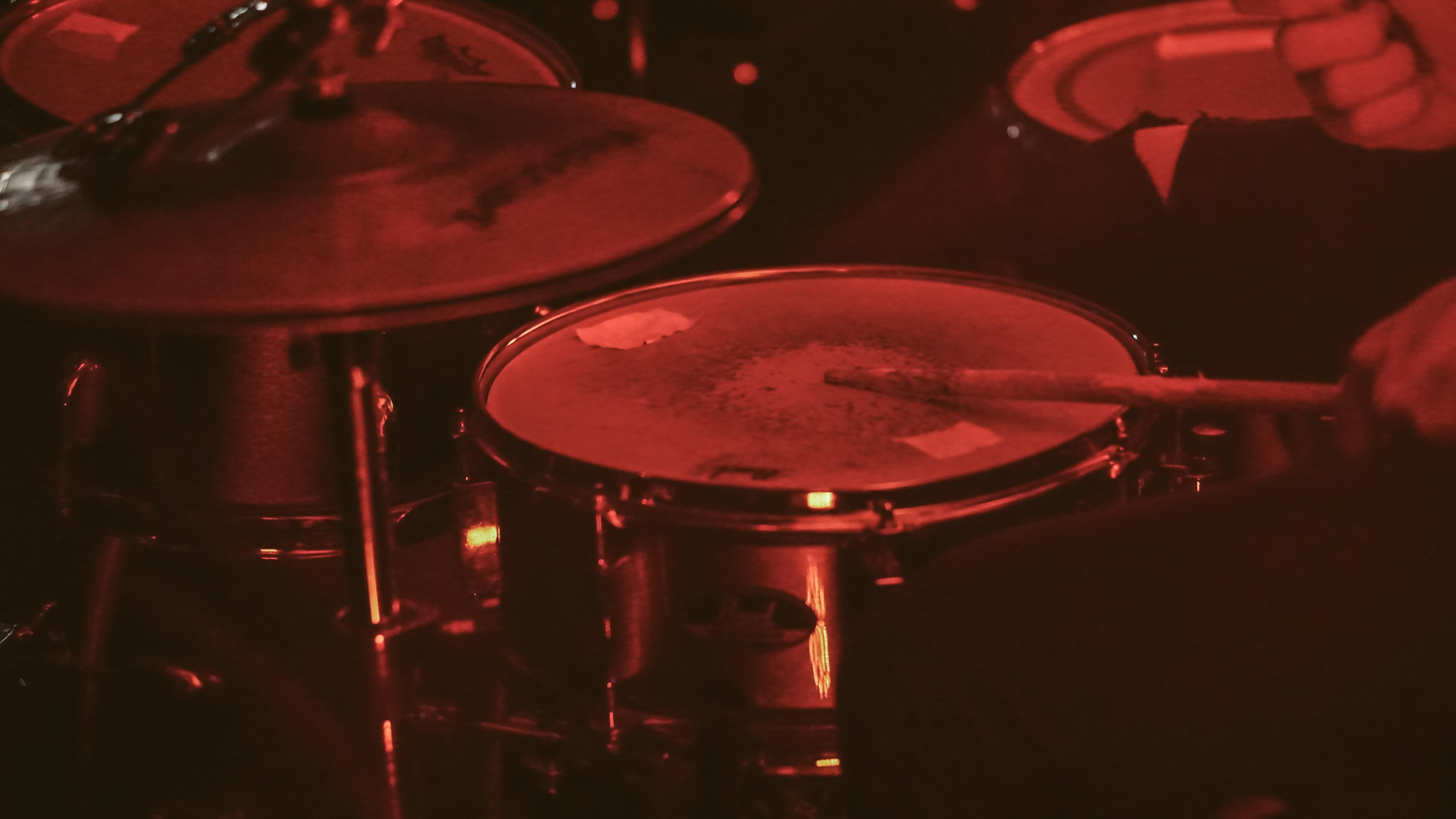 Drums with drum sticks sitting in a dark room.