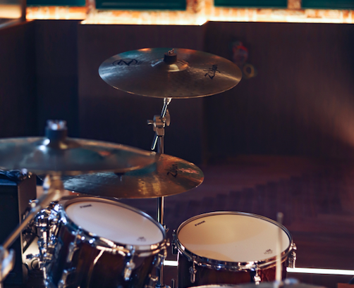Black drum set in a dark room.