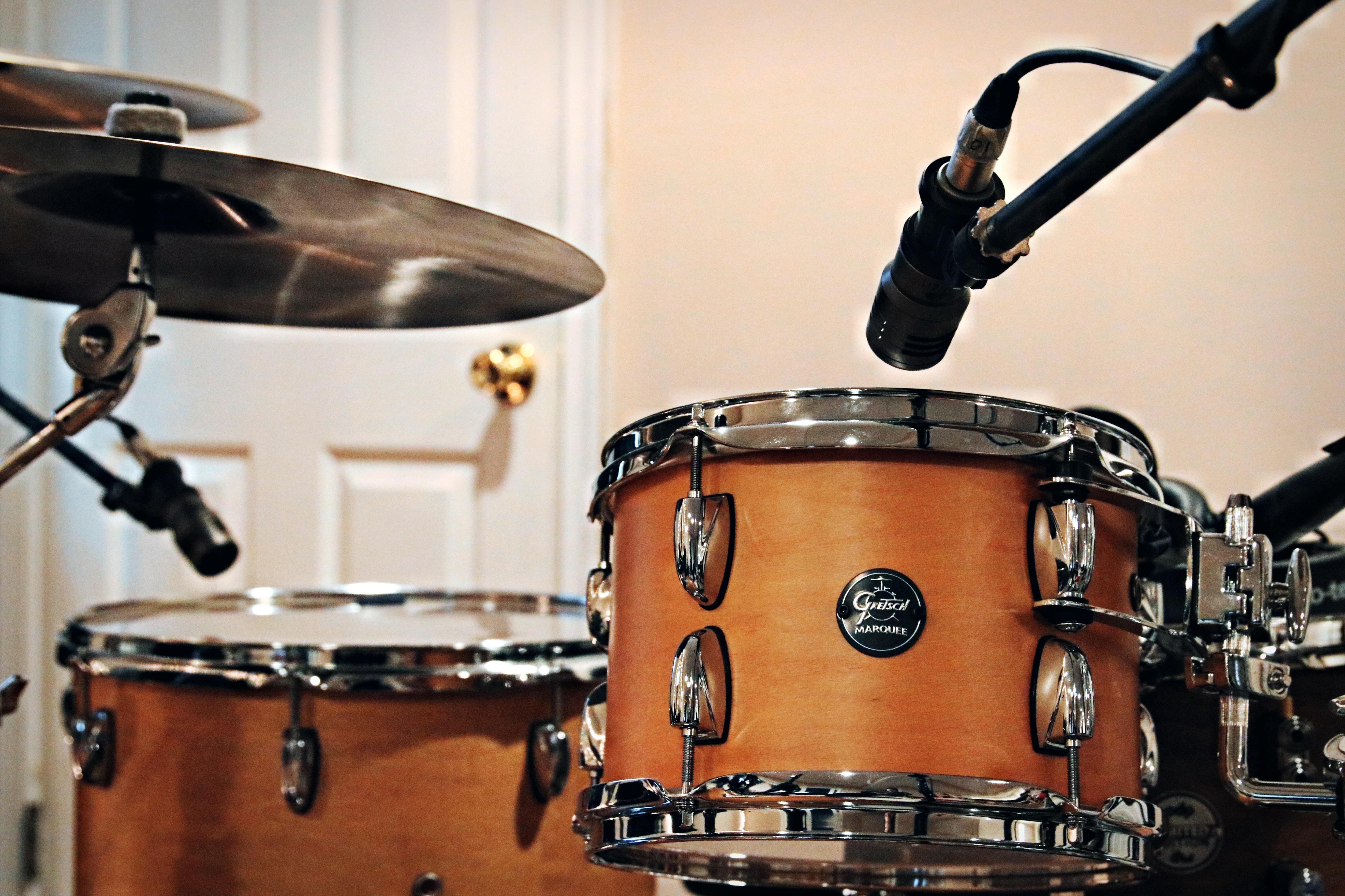 A brown drum kit sitting in a white room.