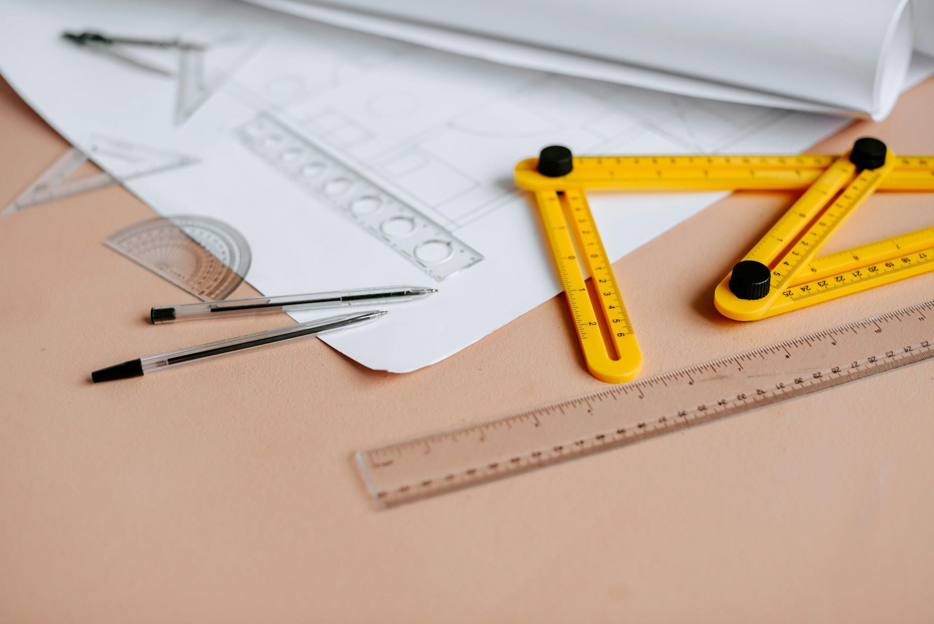 Rulers and protractors on a desk with a geometry worksheet.