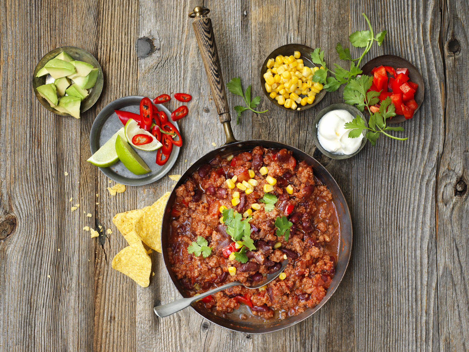 vegetarian chili set on a table with toppings and chips