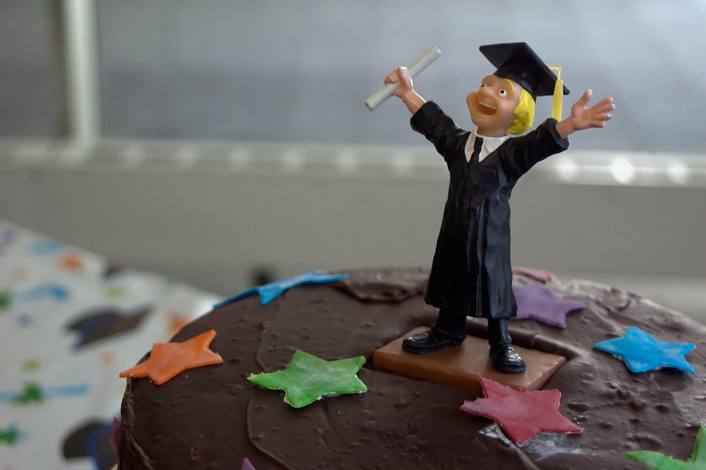 graduation chocolate cake with a graduate on top celebrating
