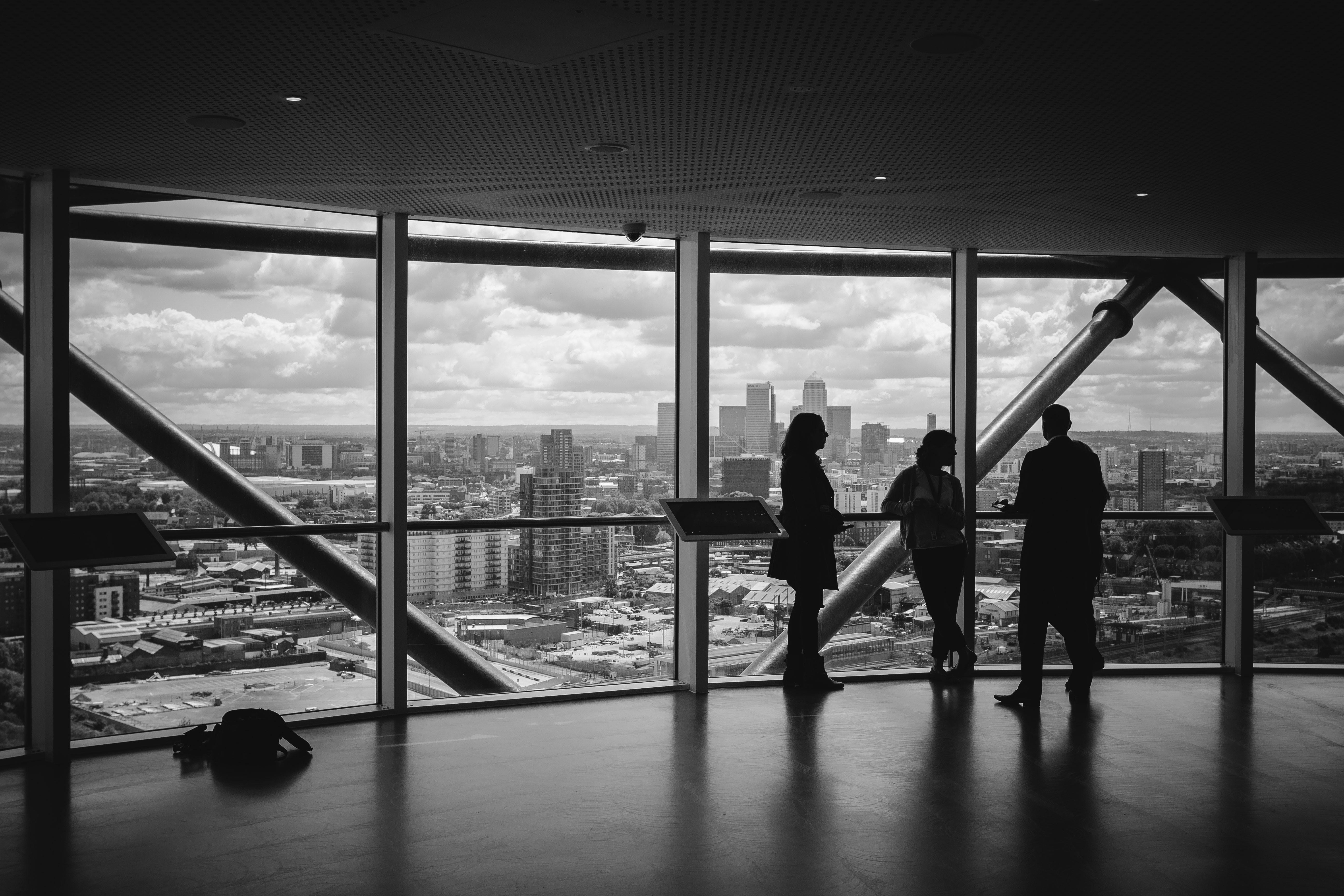 Three people standing in a large office building.