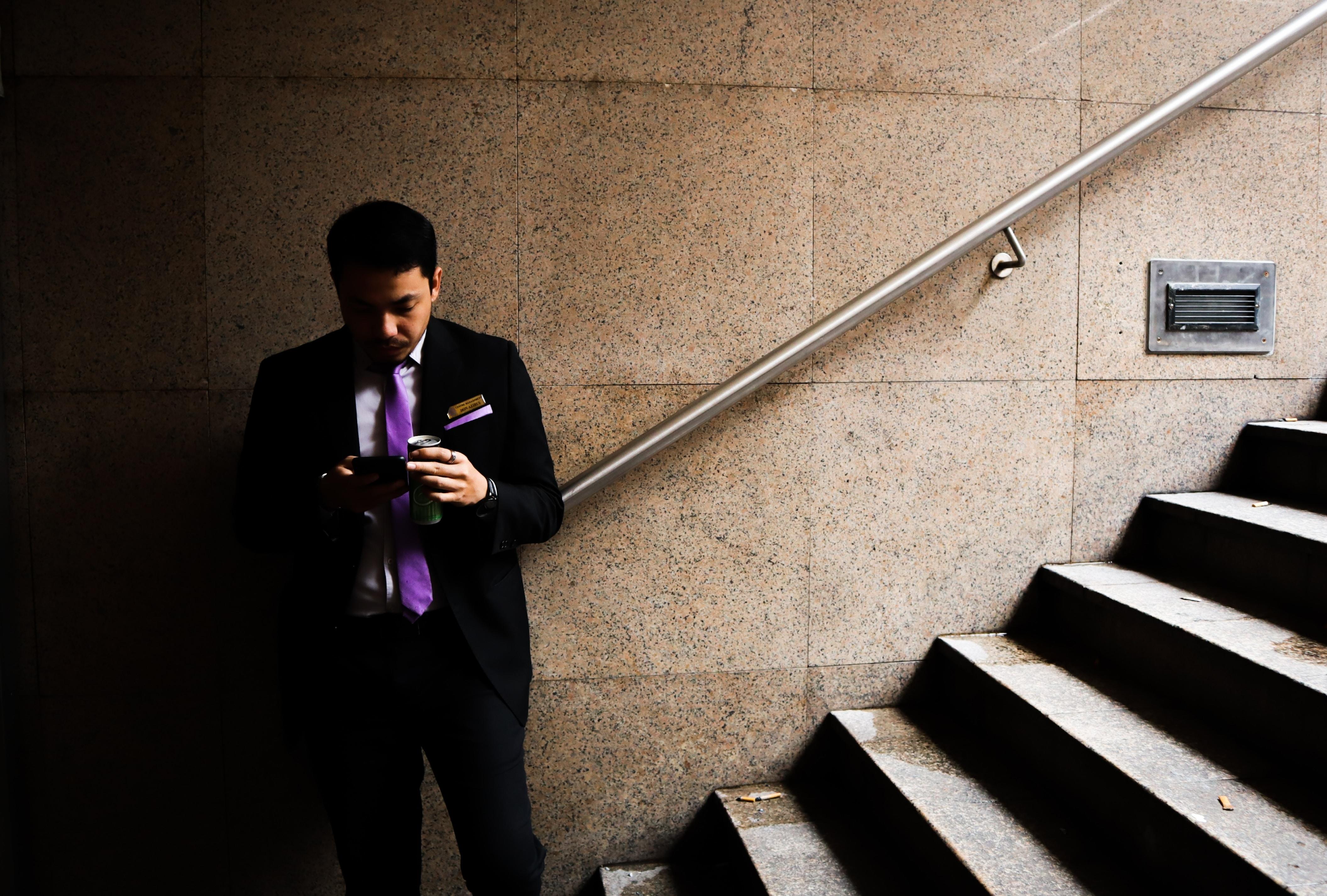 Man in suit standing next to a set of stairs.