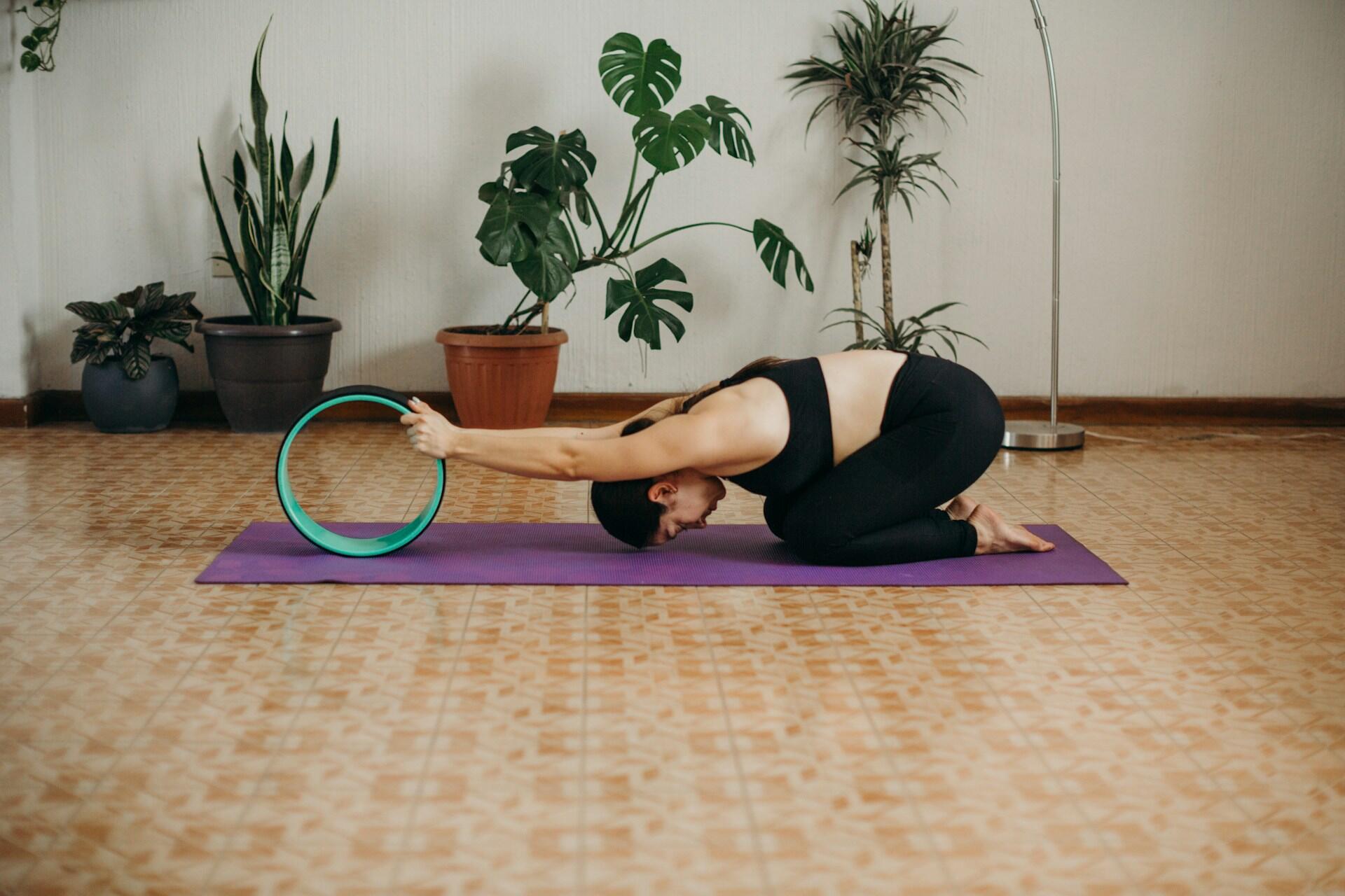 A girl stretching on a yoga bath with a ring.