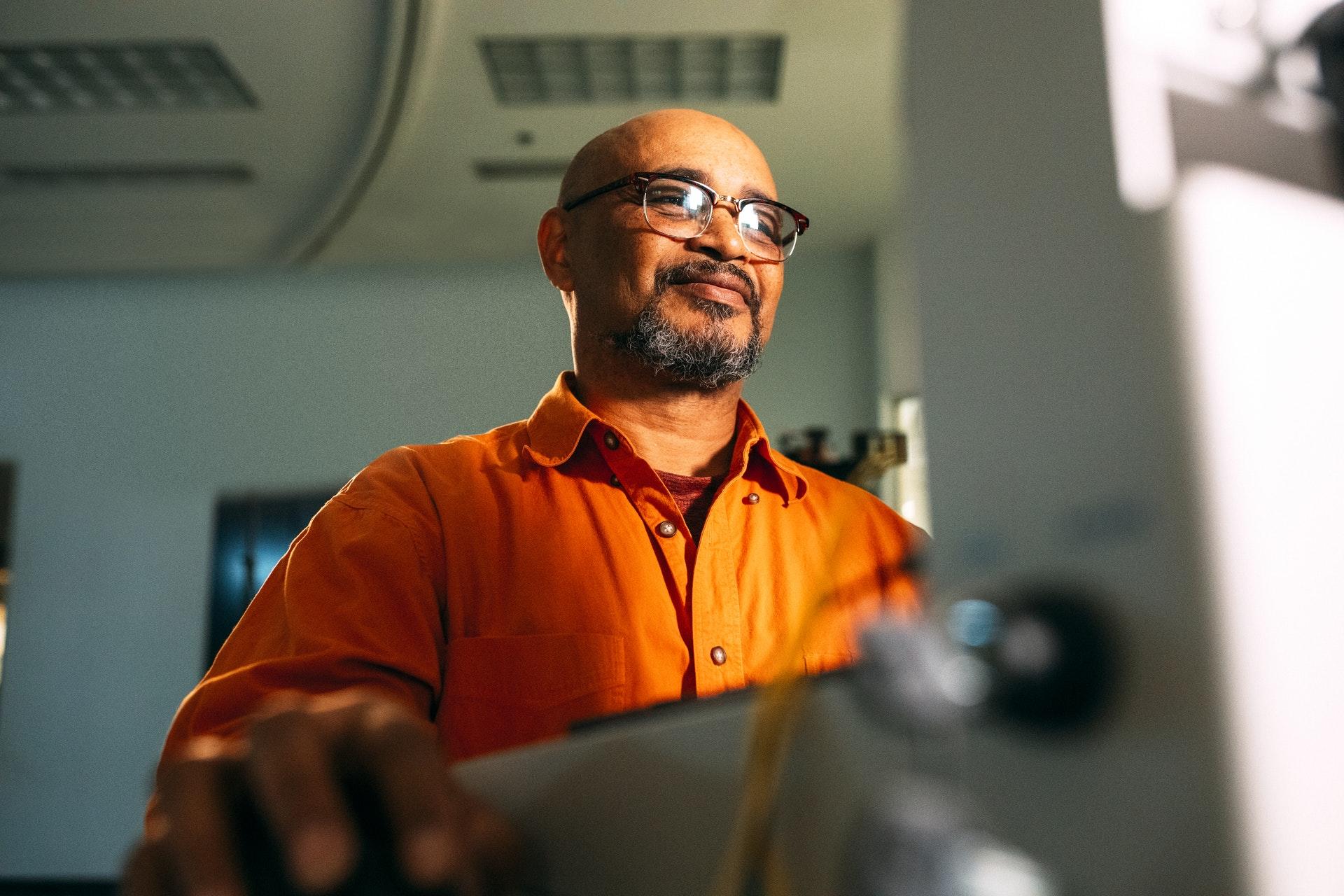 Man smiling while looking at computer.