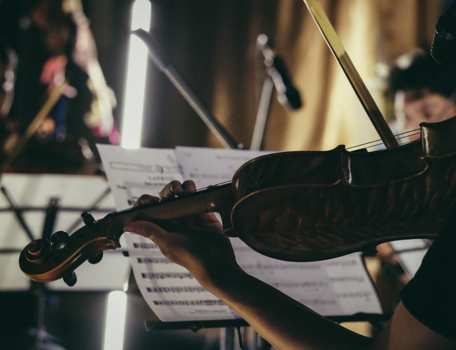 A student reading musical notes while playing the violin