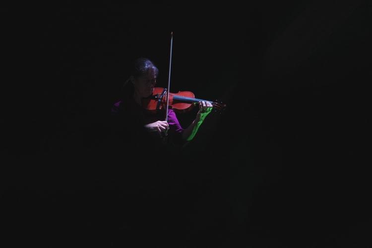 Person playing the violin at a conservatory