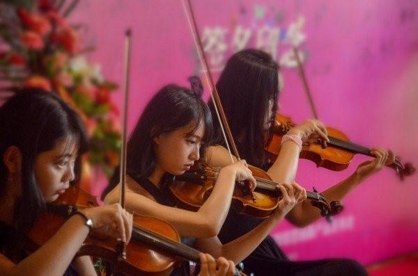 Picture of women playing the violin as part of an ensemble