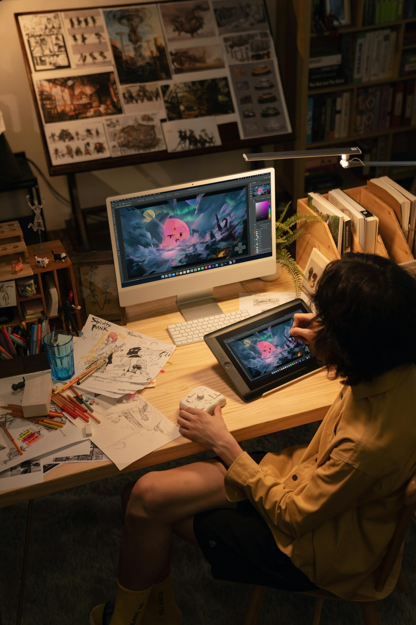 person using traditional sketches to draw on a tablet and computer