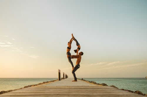 A family practicing yoga on a dock