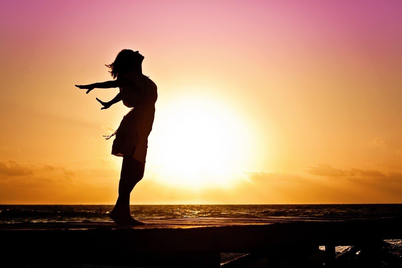 Sunset view with a shadow of a girl stretching happily