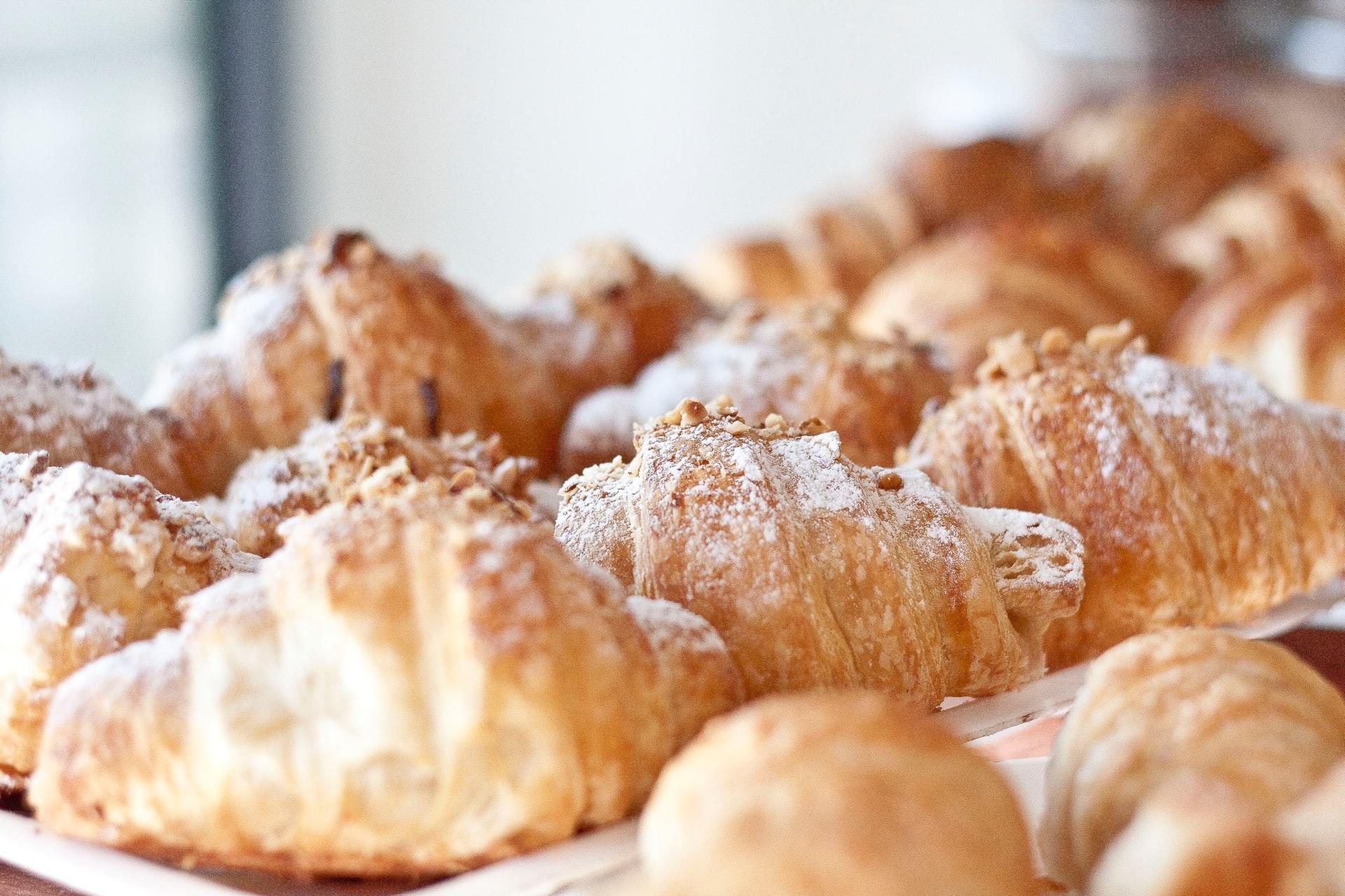 Baked croissants on display at a bakery.