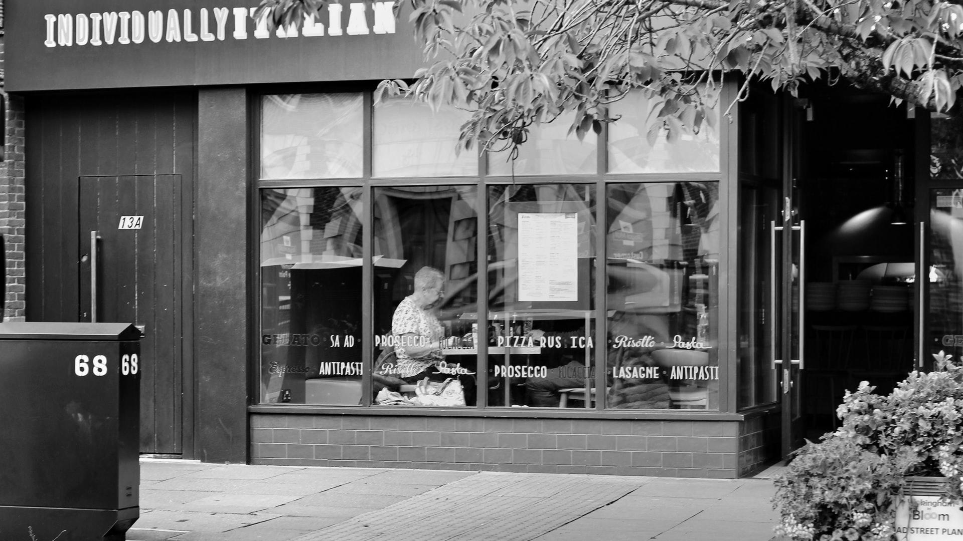 Black and white photo of the outside of an Italian restaurant.