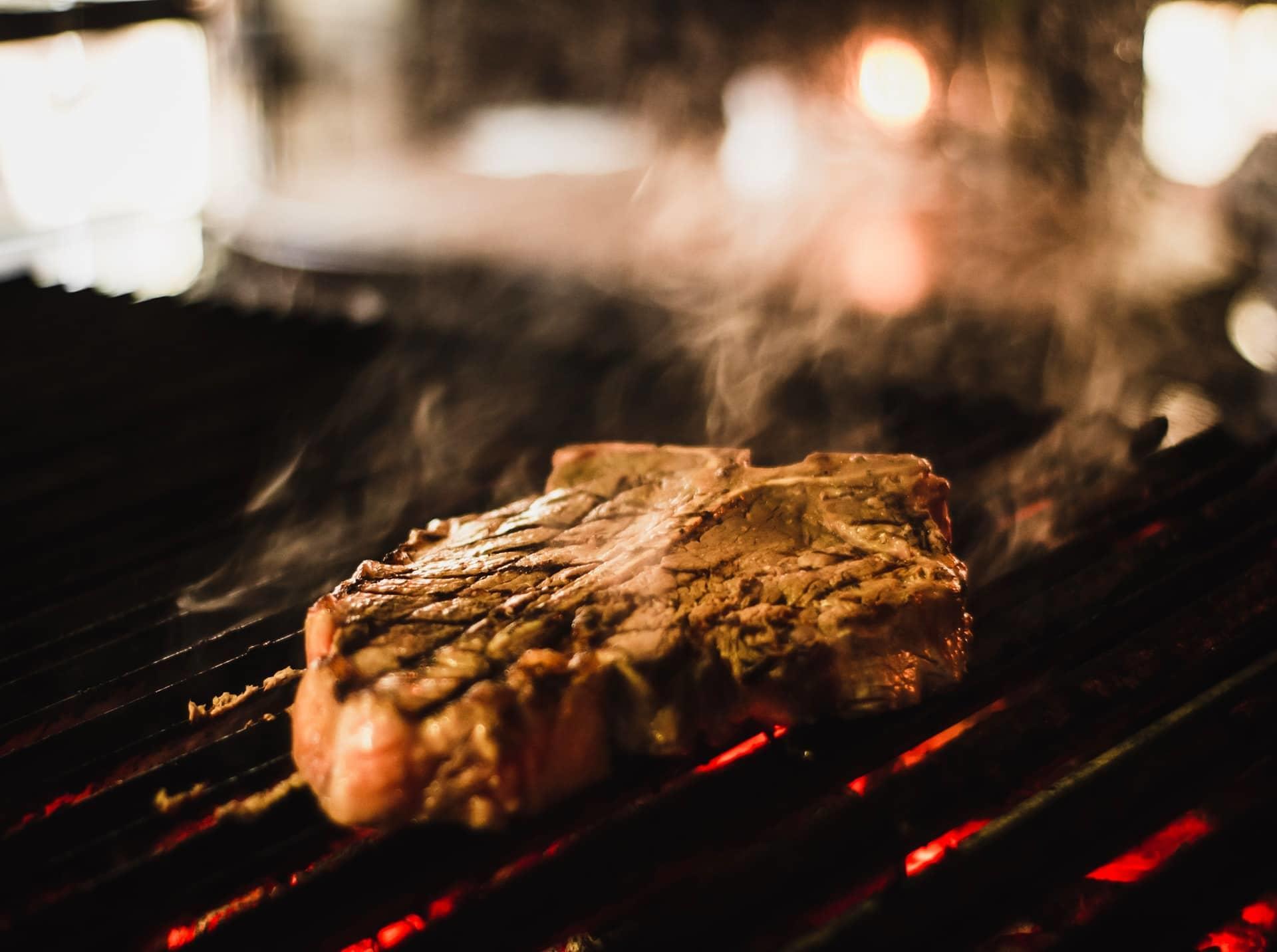 Steak being cooked on a grill.