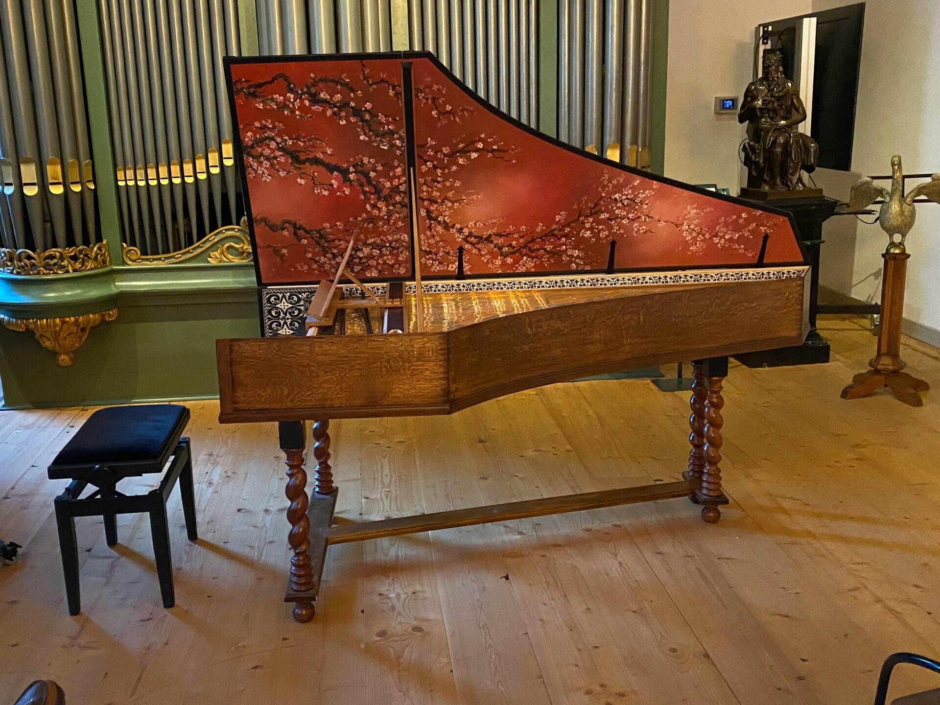 A harpsichord with flowers painted on it.