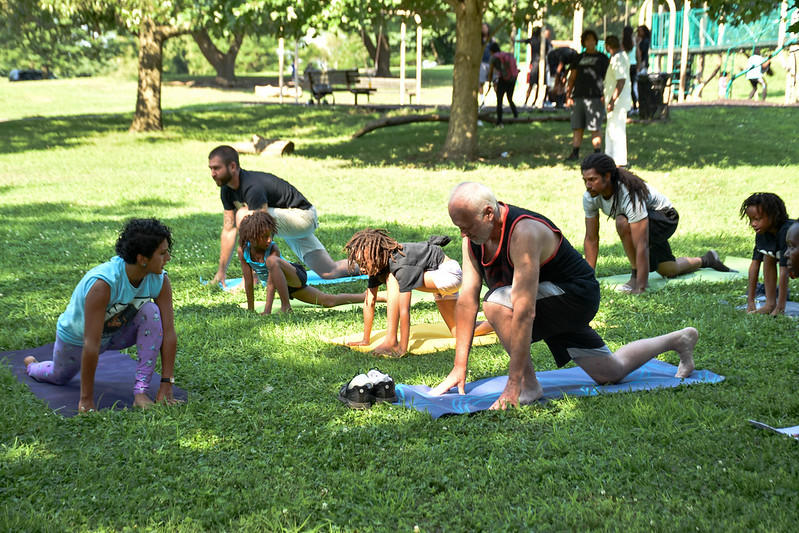 A group of students partake in a yoga class outdoors. 