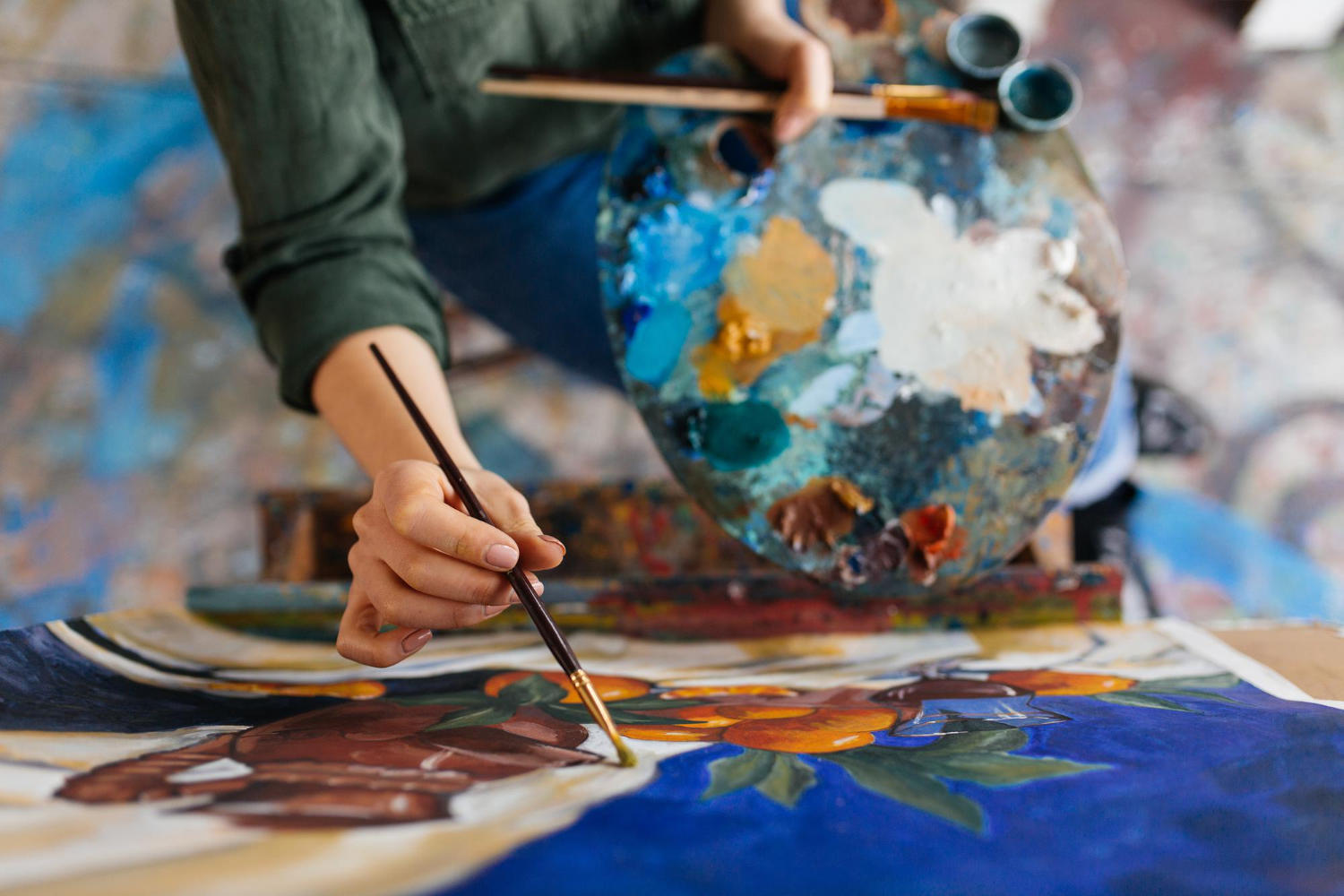 An artist painting a canvas in her studio