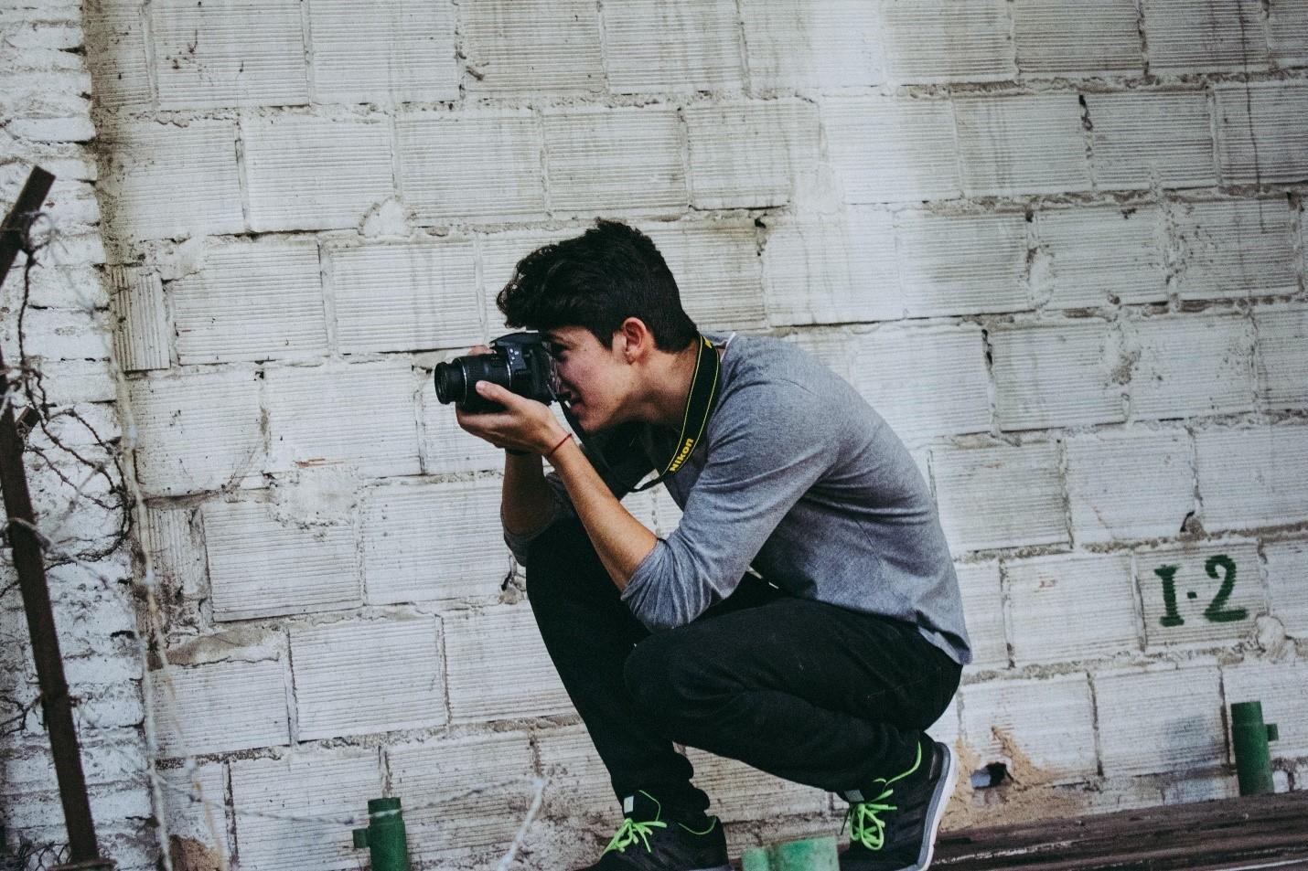 A student clicking a picture in a photography class
