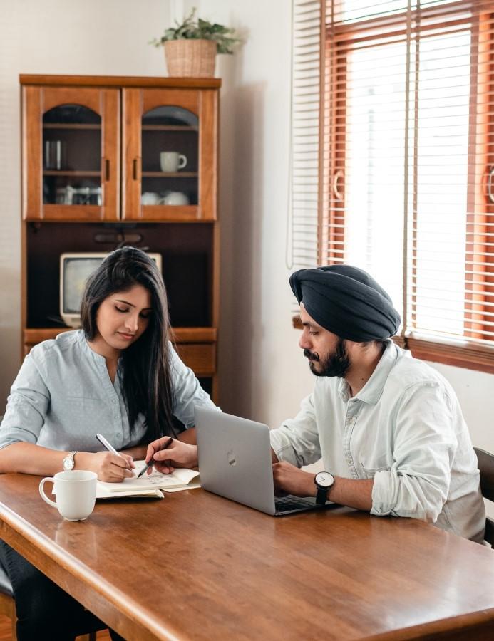 Tutor helping students while using a laptop